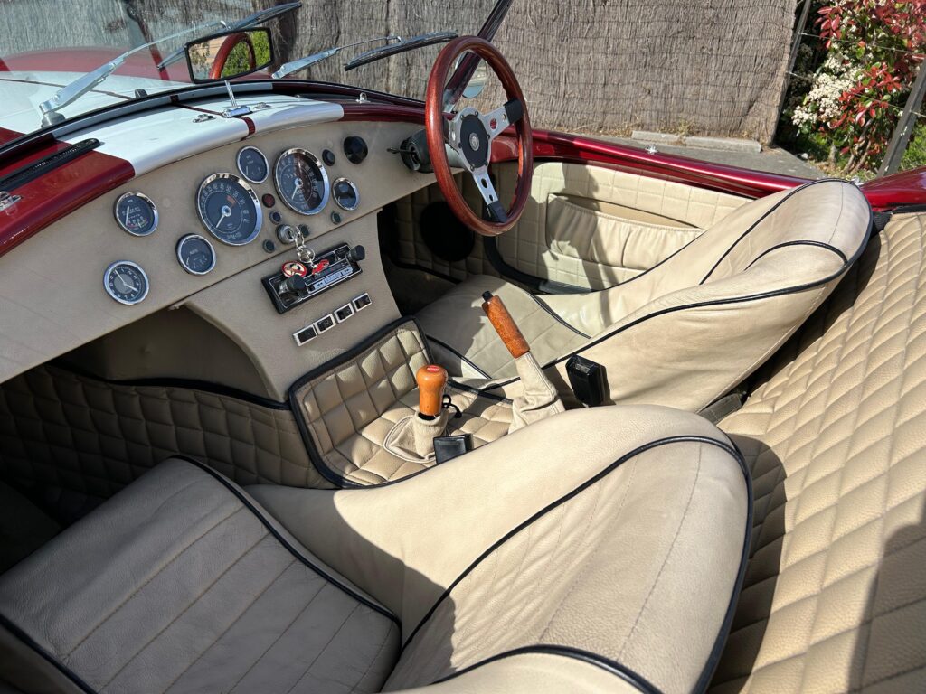 Primer plano de un AC Cobra rojo con rayas de competición blancas, ideal para el alquiler en eventos corporativos y rodajes. Disponible en Bilbao y País Vasco.