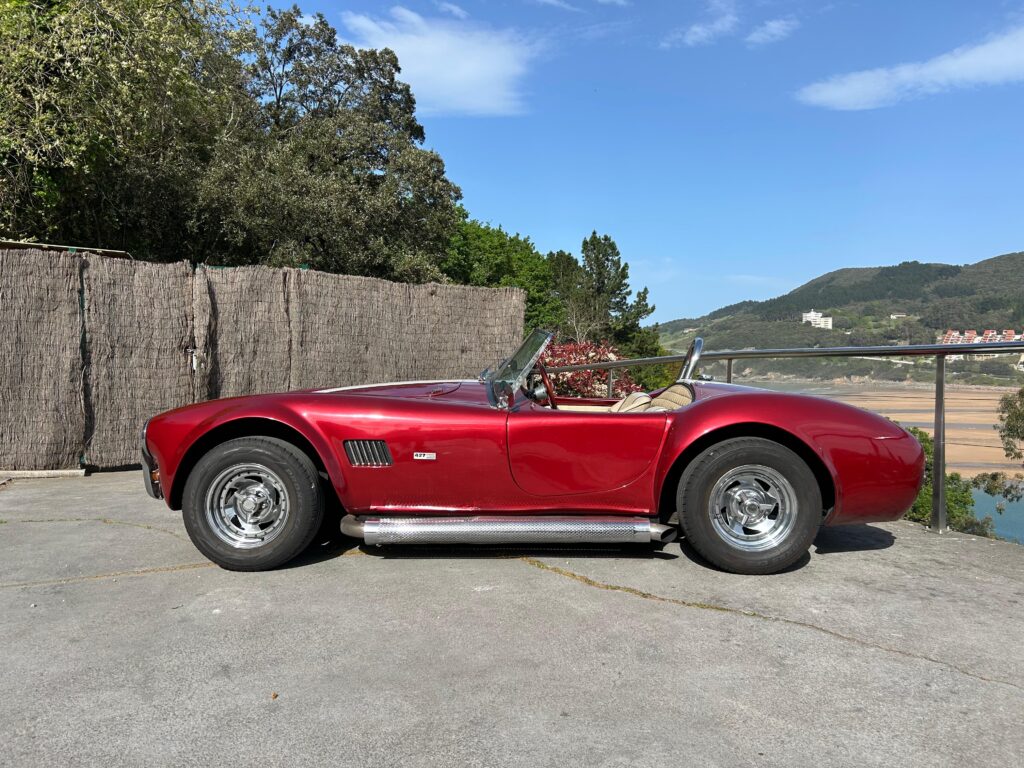 Primer plano de un AC Cobra rojo con rayas de competición blancas, ideal para el alquiler en eventos corporativos y rodajes. Disponible en Bilbao y País Vasco.